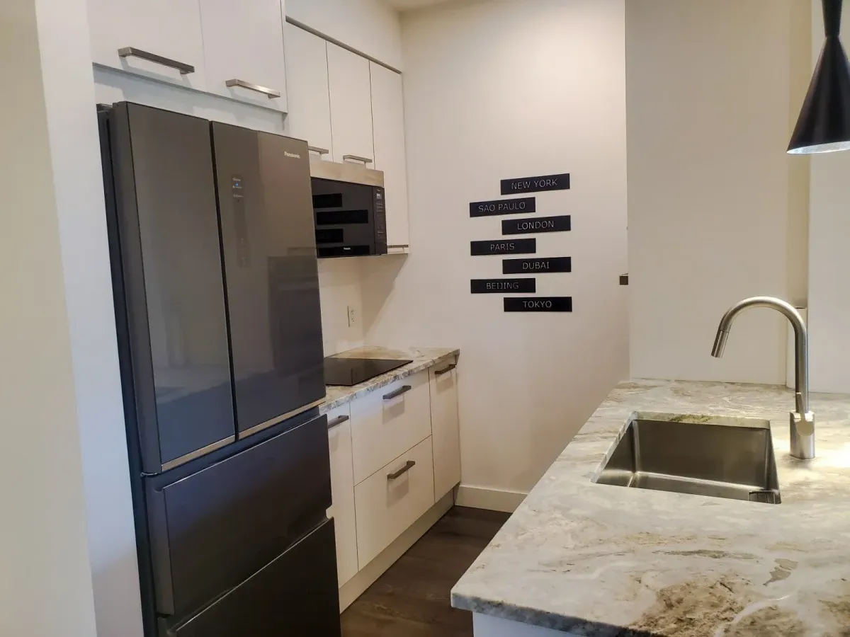 Gourmet kitchen island at 11 Beausoleil #105 with an undermount sink and modern pendant lighting.