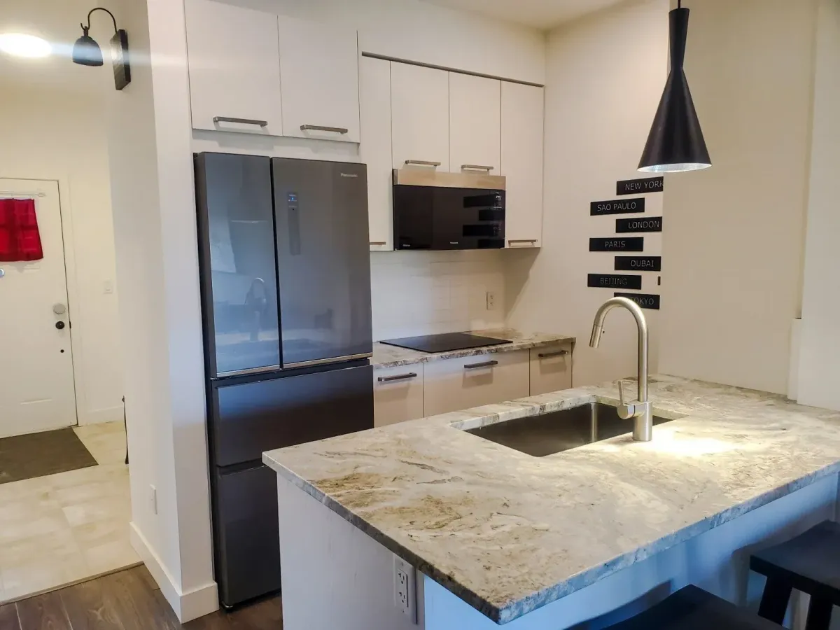 Modern kitchen at 11 Beausoleil #105 featuring high-end built-in appliances and quartz countertops.