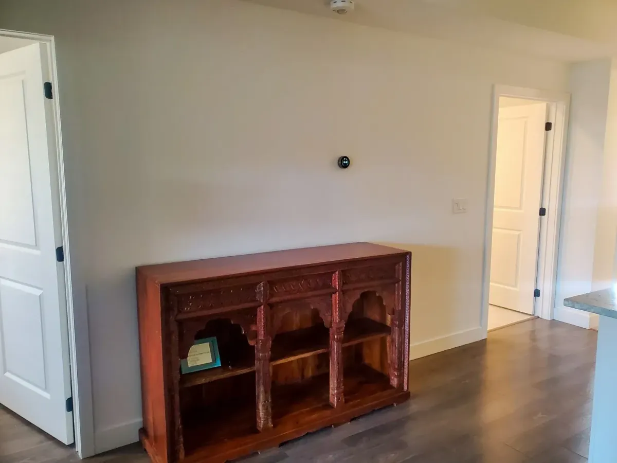 Functional entry area at 11 Beausoleil #105 featuring a rustic wood sideboard and modern lighting.