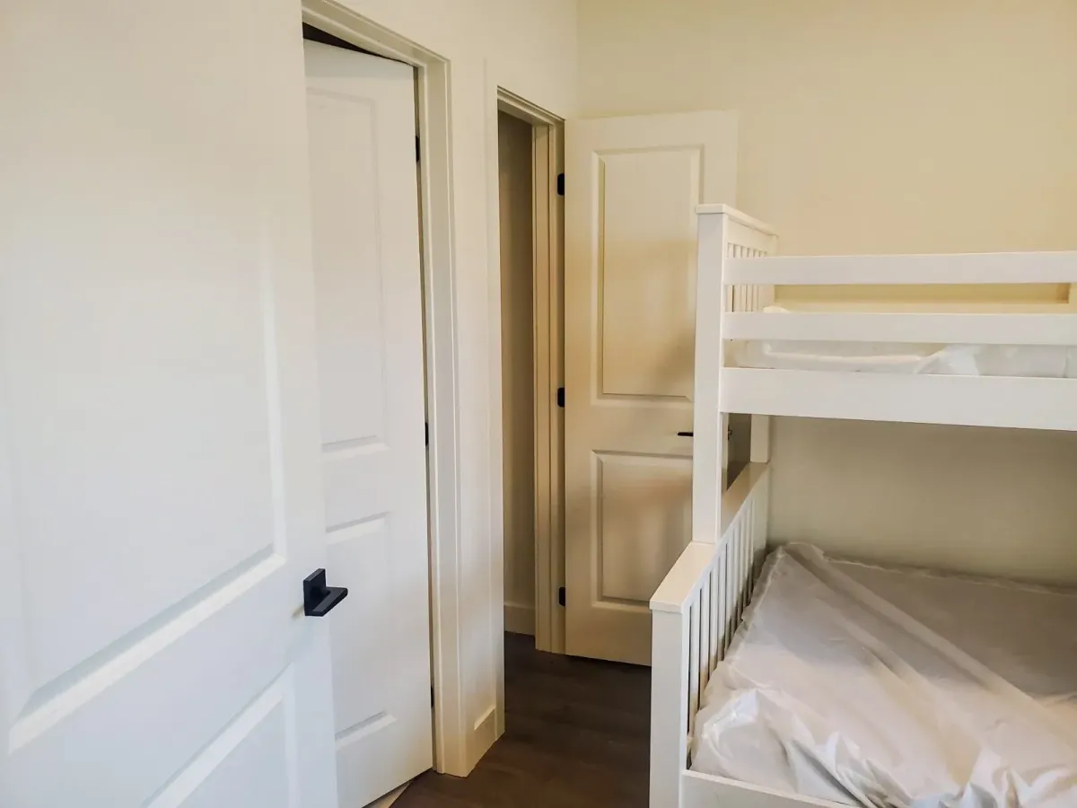 Secondary bedroom at 11 Beausoleil #105 configured with high-quality white bunk beds.