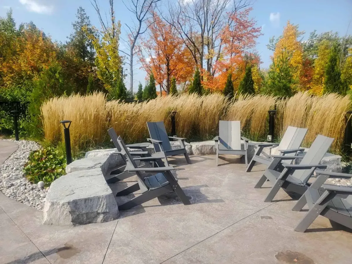 Outdoor social area at 11 Beausoleil featuring Adirondack chairs and a central fire pit.