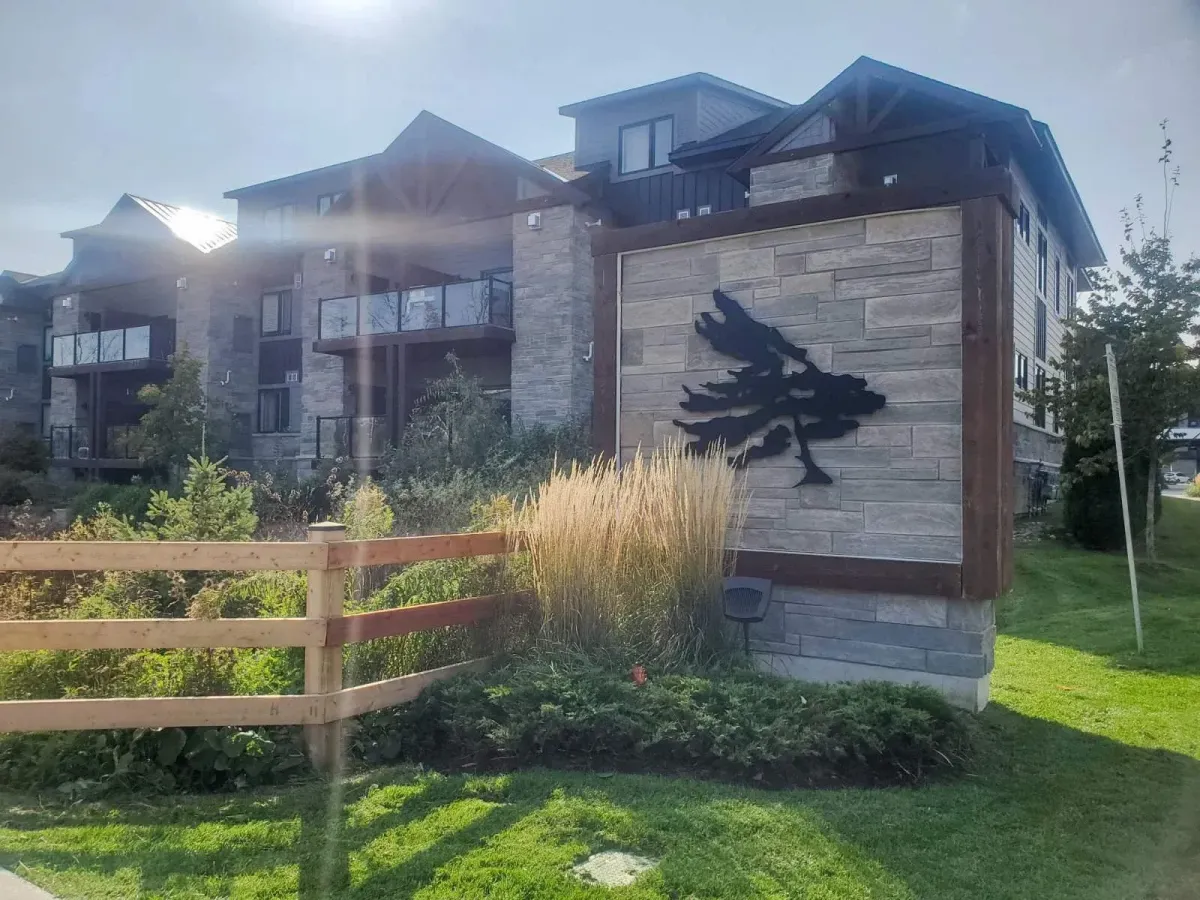 Exterior of the luxury condo building at 11 Beausoleil featuring stone accents and timber framing.