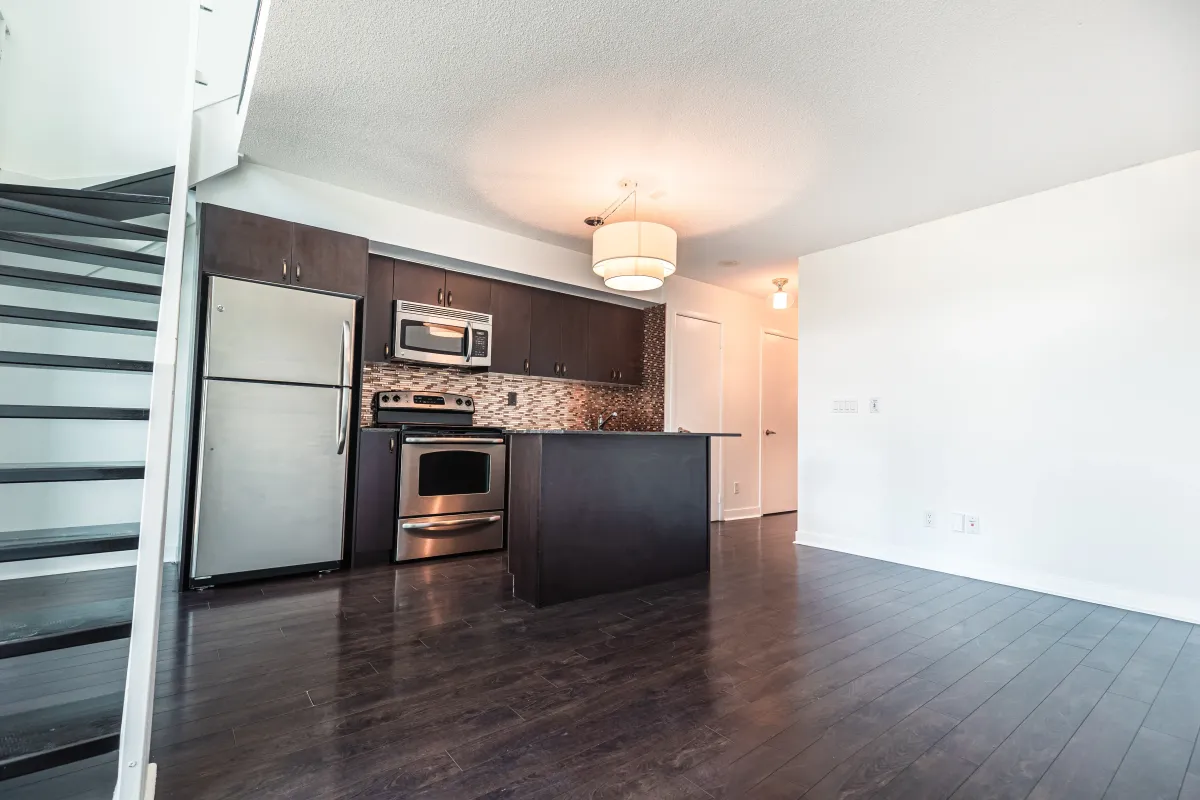 Modern kitchen at 155 Legion Rd N #2311 with stainless steel appliances, dark cabinetry, and an integrated dining island.