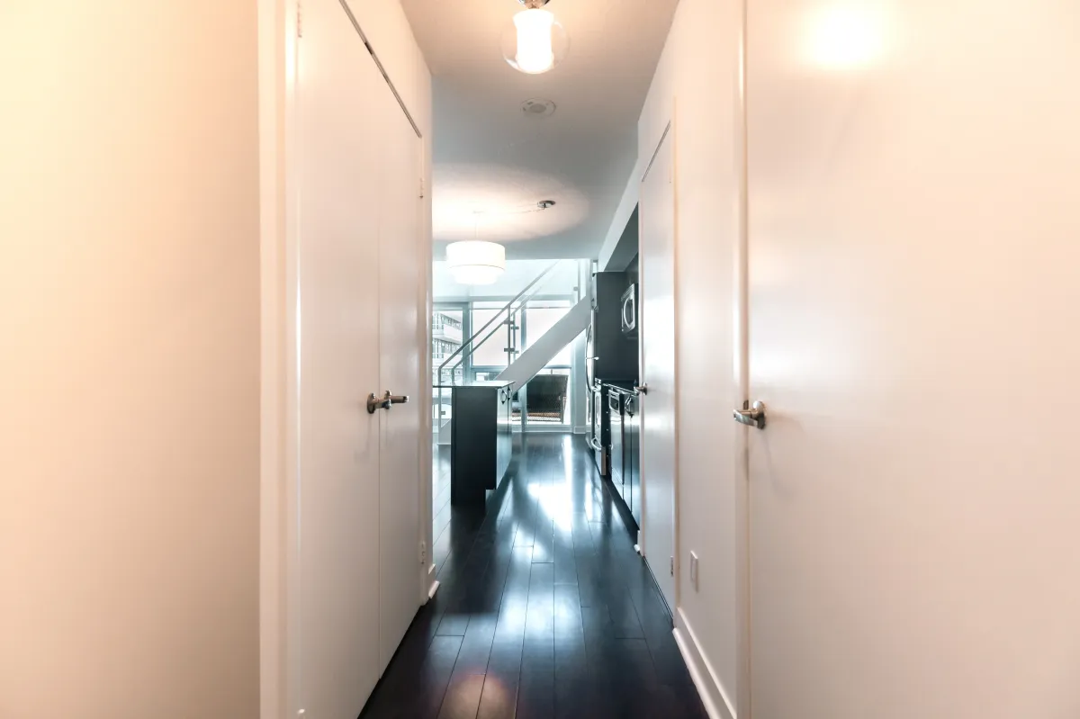 Entry hallway at 155 Legion Rd N #2311 featuring clean white walls and access to the main floor powder room.