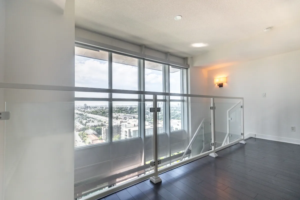 Glass mezzanine at 155 Legion Rd N #2311 providing a clear view of the lower level and urban skyline.