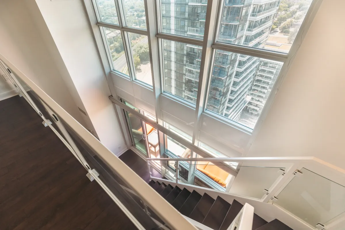 High-angle view from the loft at 155 Legion Rd N #2311 looking down into the sun-filled living room.