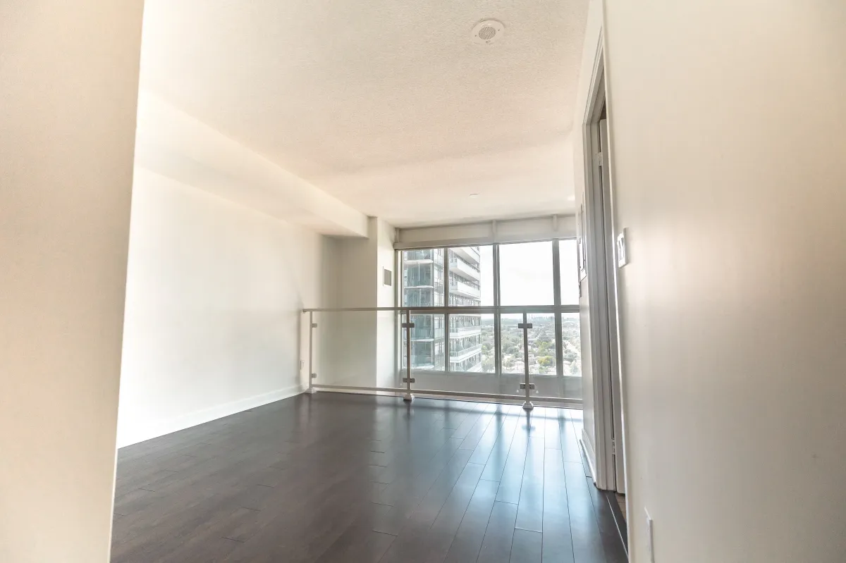 Expansive loft bedroom at 155 Legion Rd N #2311 overlooking the main living area with dark wood floors.