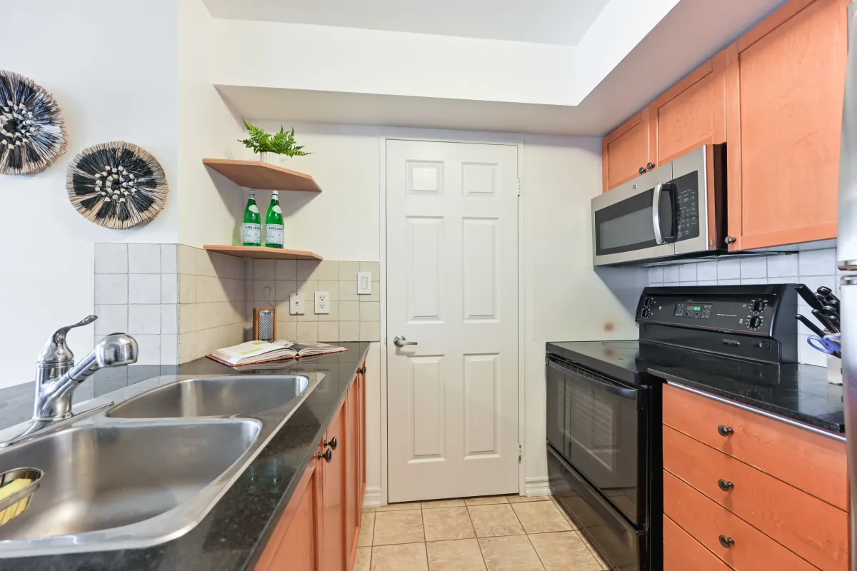 Close-up of the durable granite counters and sleek cabinetry in the modern kitchen of 1369 Bloor St W, Suite 1416.