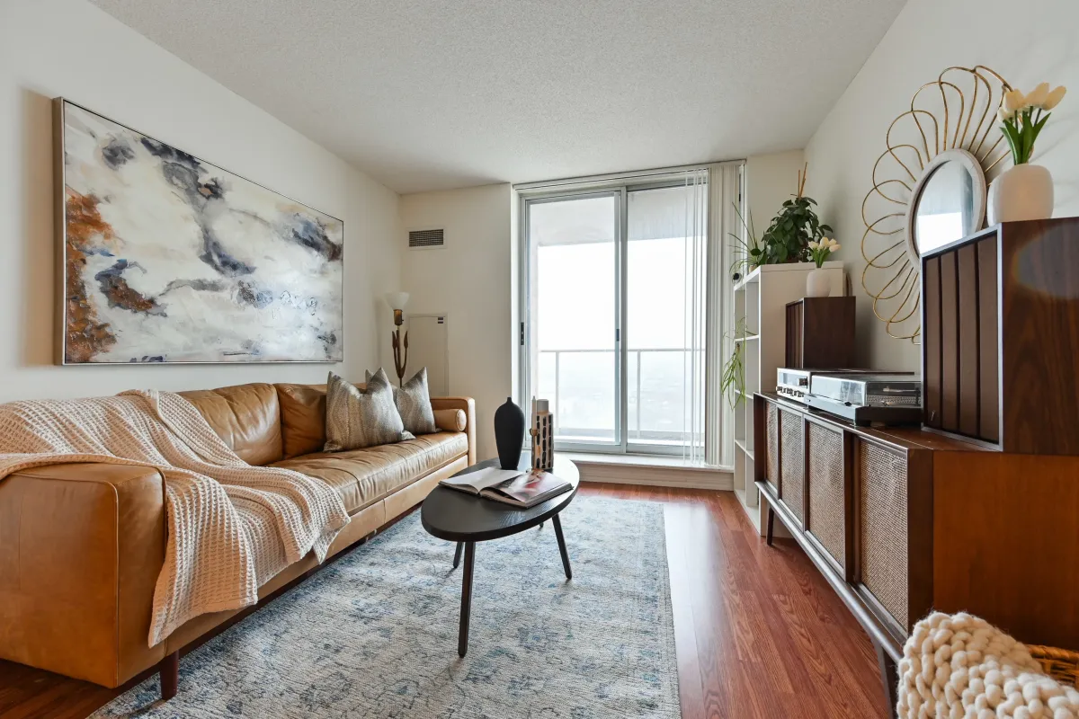 Modern living room at 1369 Bloor St W, Suite 1416, with large windows overlooking the Toronto skyline and West End landmarks.