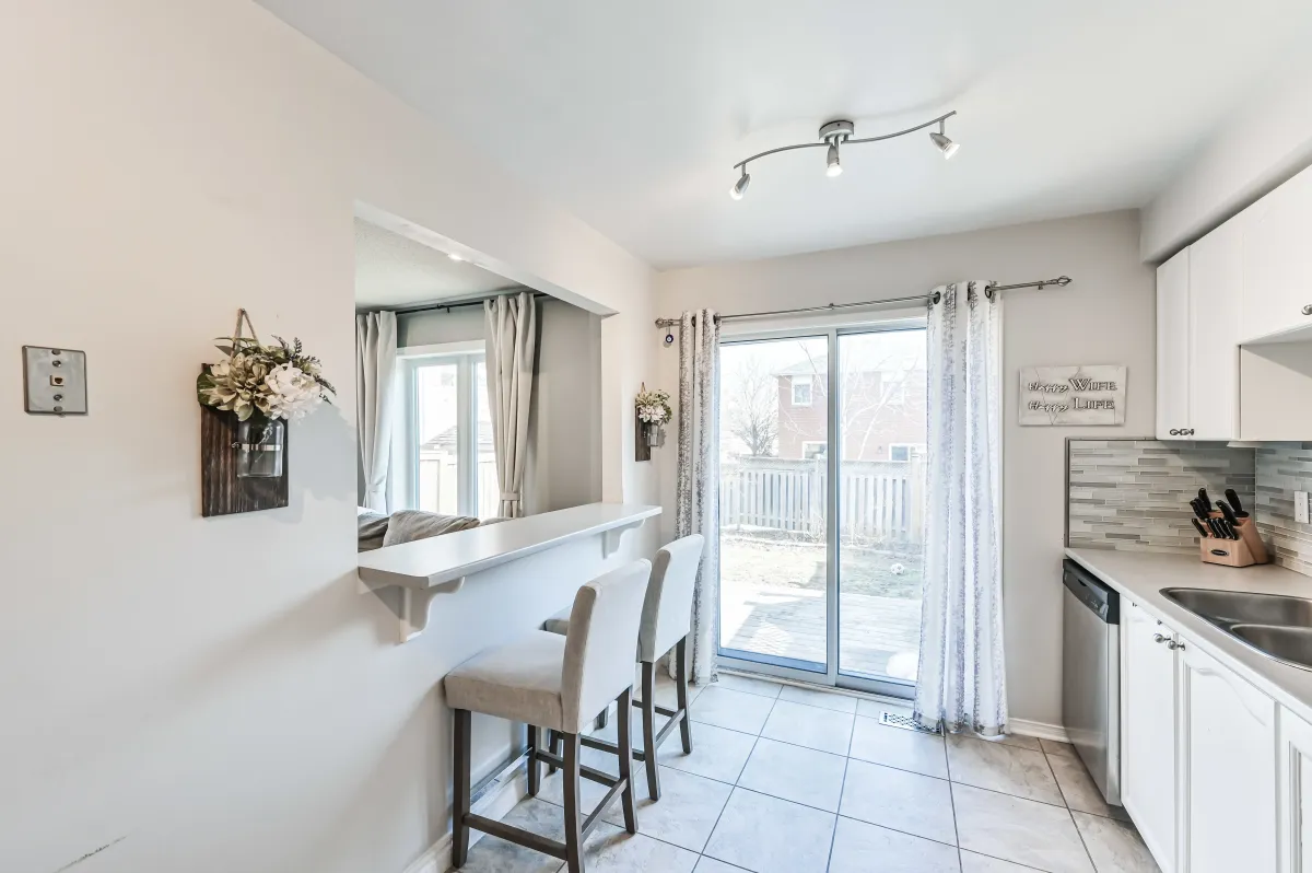 Spacious eat-in kitchen at 133 Howard Crescent, featuring a breakfast bar and walk-out to the private backyard.