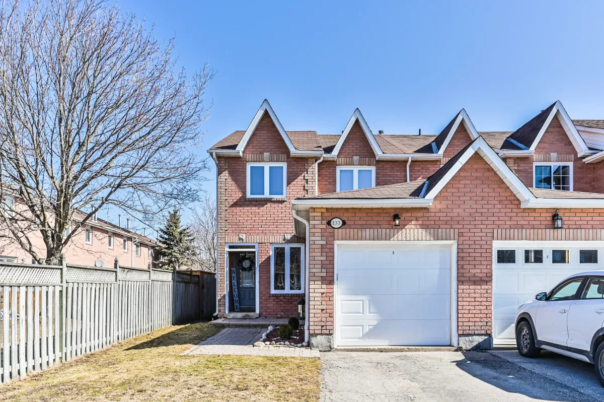 Angled front view of the brick two-storey residence at 133 Howard Crescent, highlighting the private driveway and end-unit privacy.