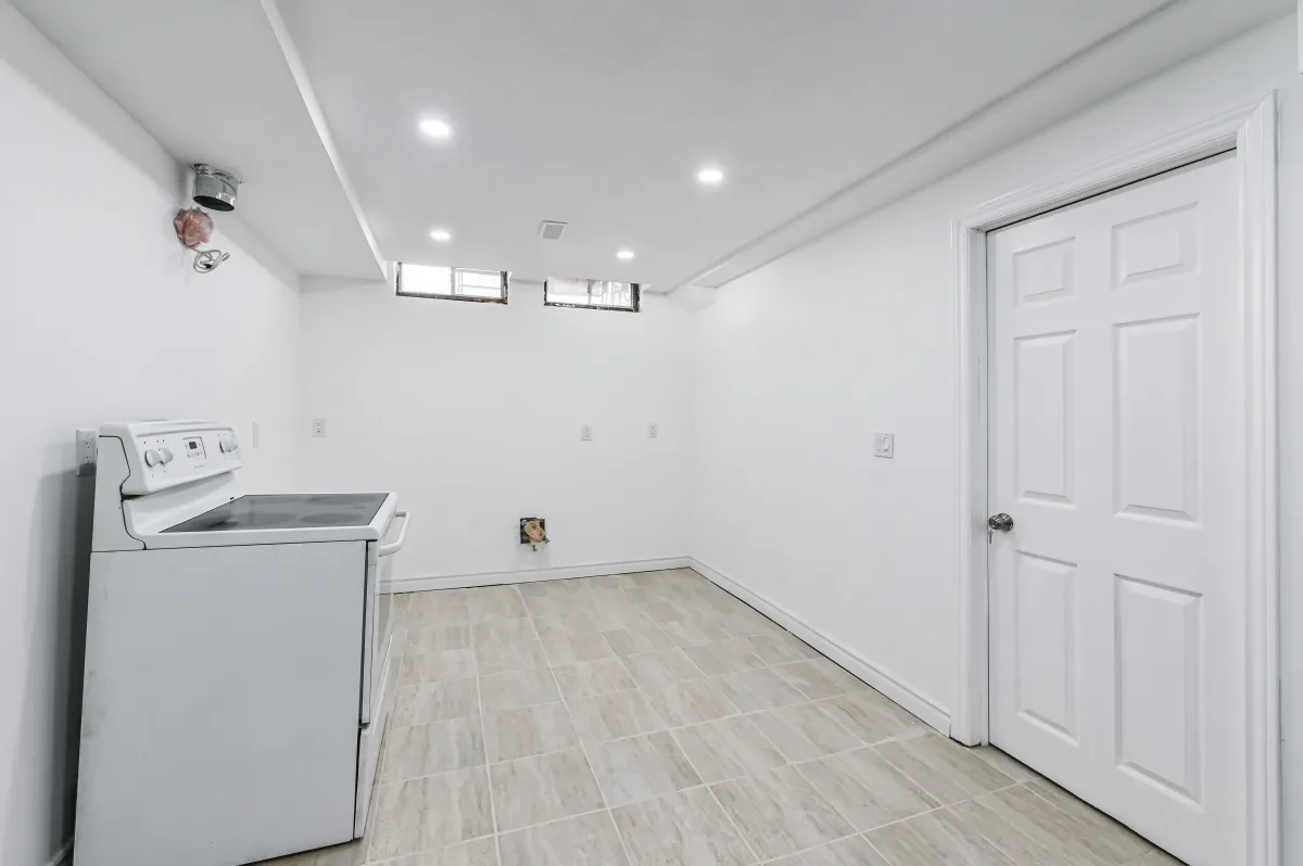 Laundry and utility room in the basement of 133 Howard Crescent, providing plenty of storage.