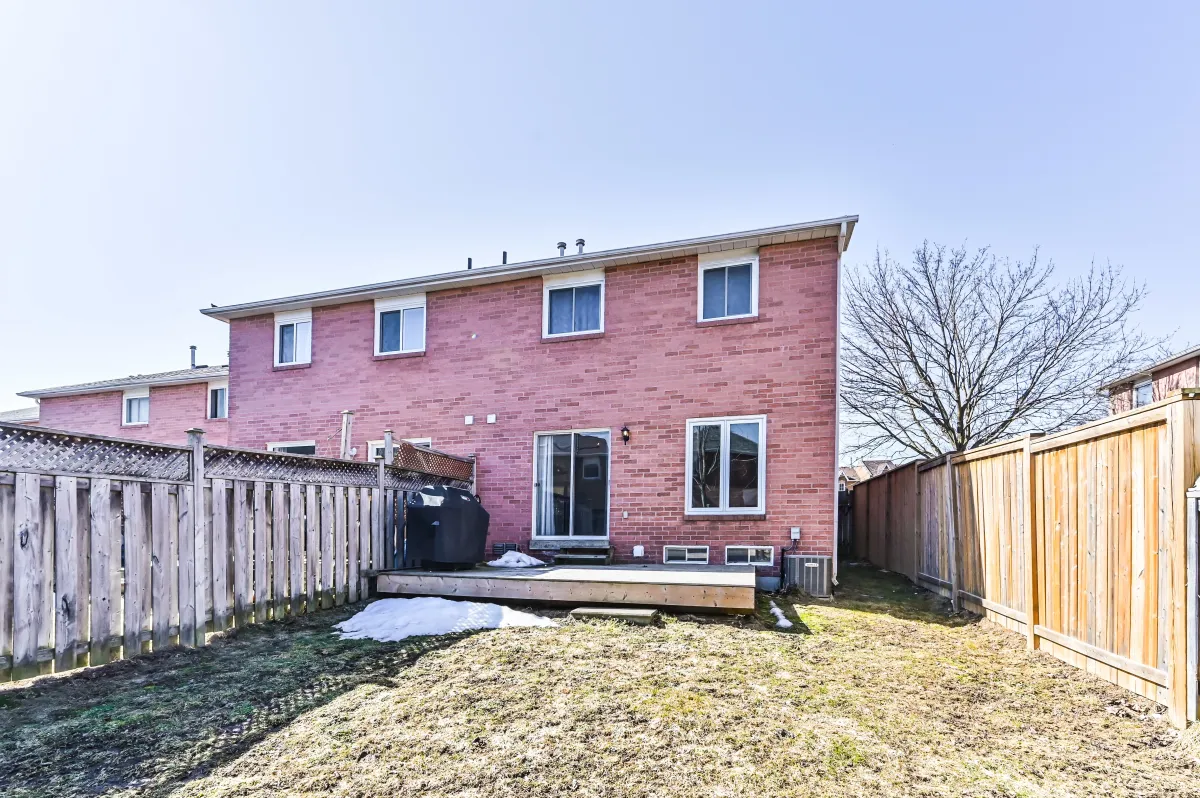 Exterior rear view of 133 Howard Crescent, showing the brick townhouse facade and secure outdoor play area.