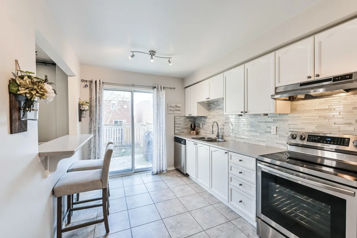 Transition from the dining room to the eat-in kitchen at 133 Howard Crescent, highlighting the functional main floor layout.