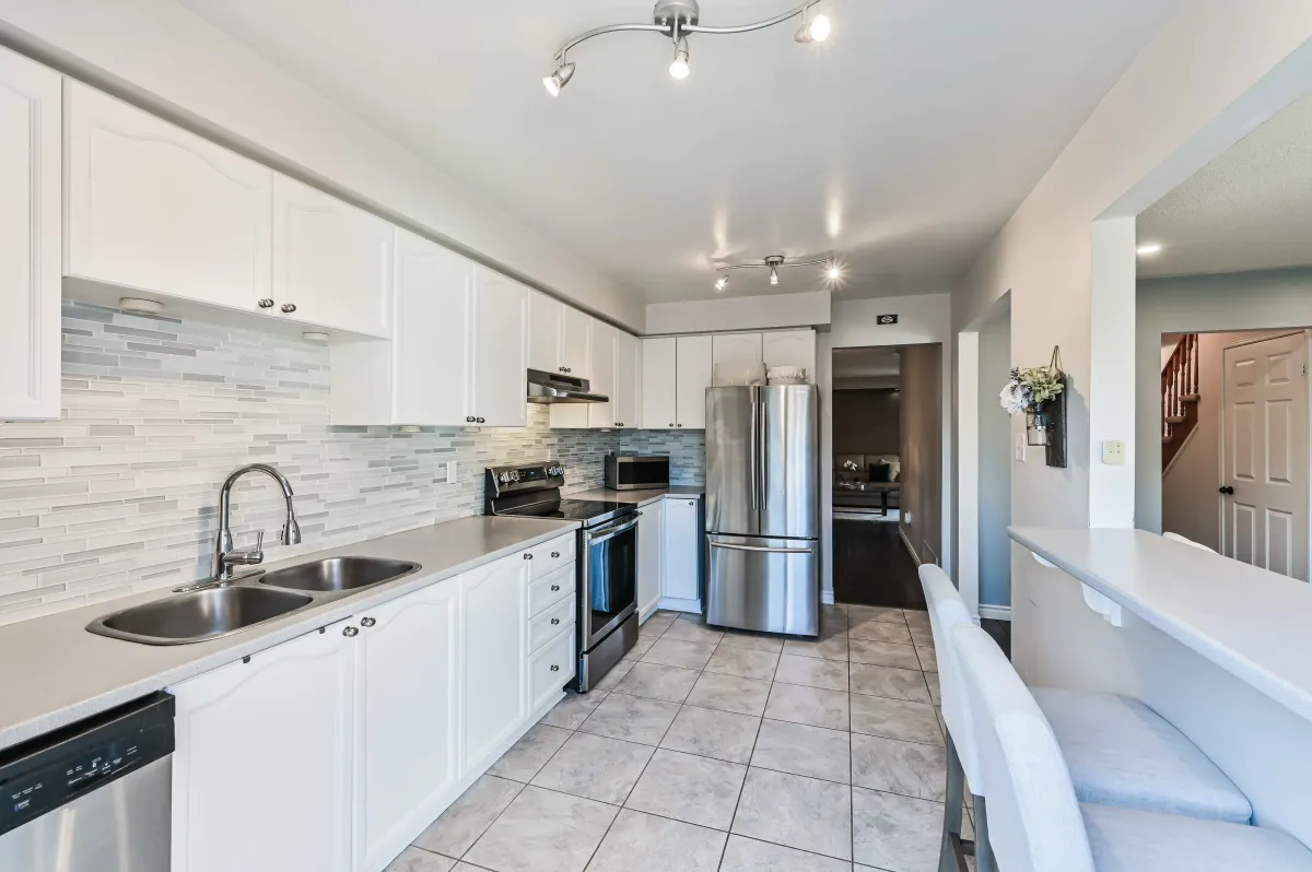 Alternate view of the kitchen at 133 Howard Crescent, showcasing the sleek finishes and bright atmosphere.
