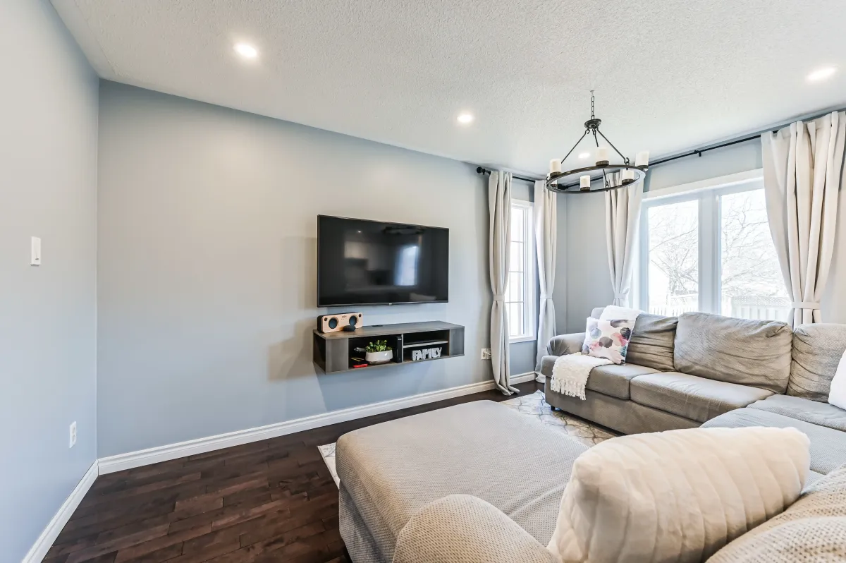 Alternate angle of the family room at 133 Howard Crescent, looking toward the main floor living space and hardwood flooring.