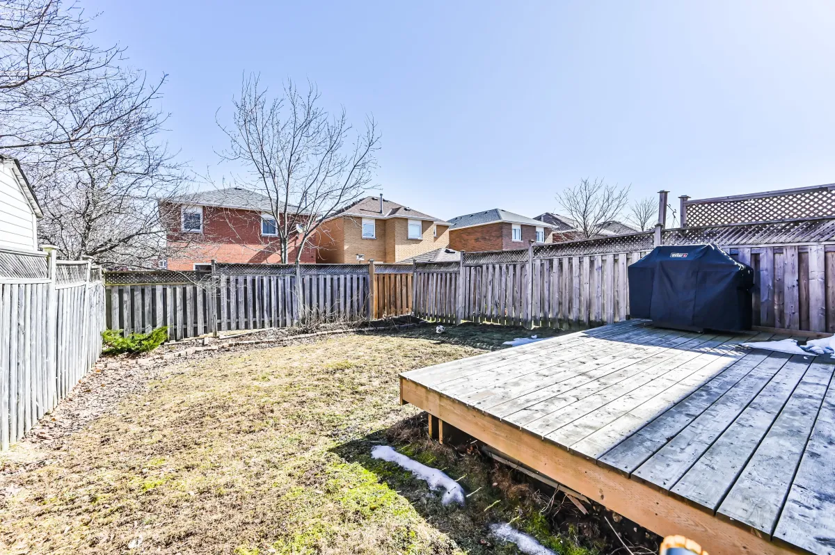 Fully fenced-in private backyard at 133 Howard Crescent, featuring a deck for summer BBQs.