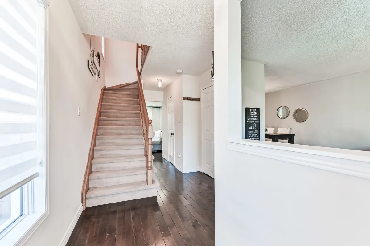 Clean and bright hallway at 133 Howard Crescent, leading to the upper level and main floor powder room.