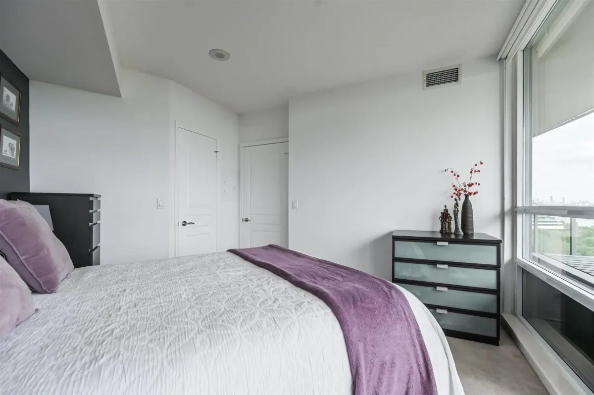 bedroom with large window and beautiful view of the city, lake and park