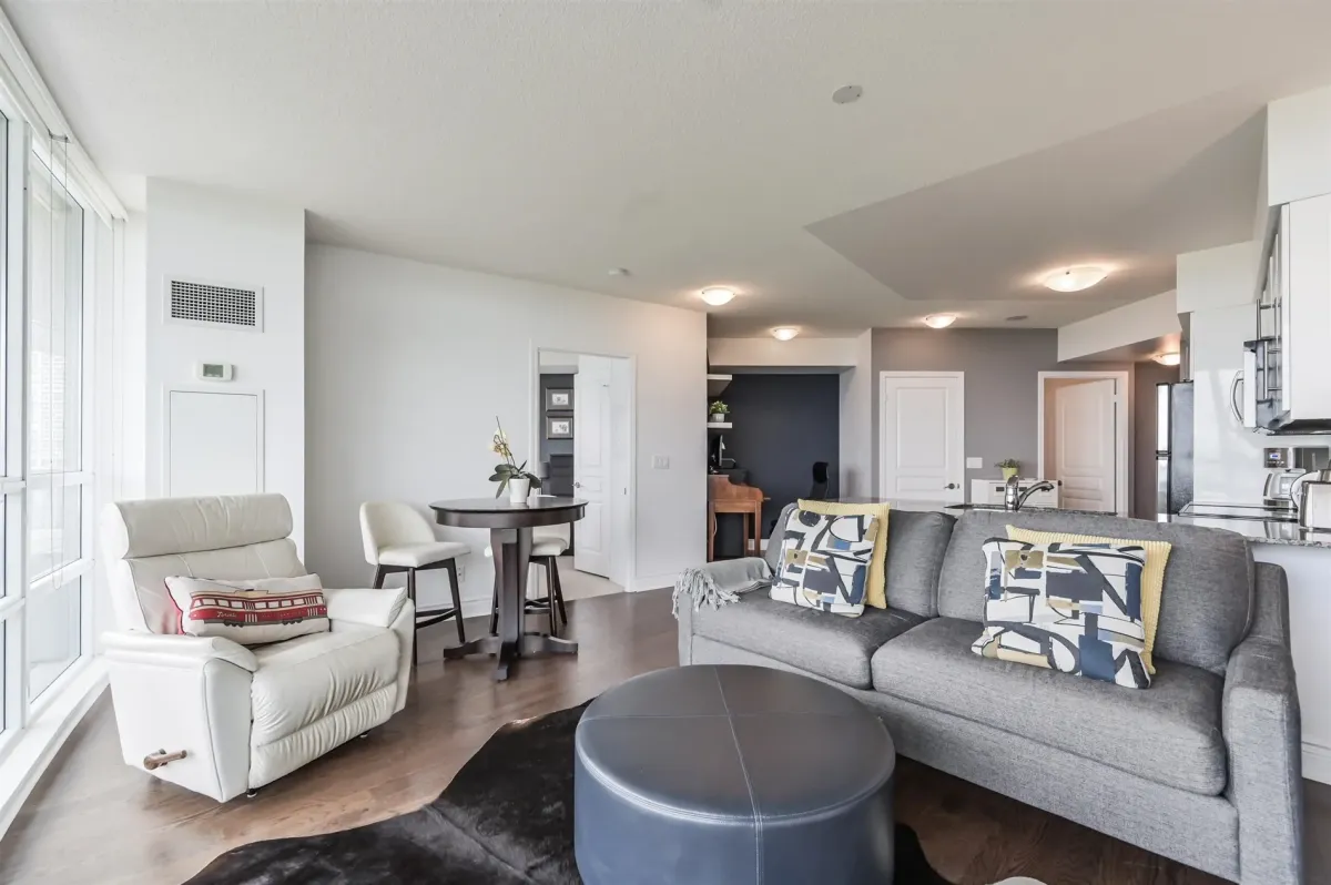 Bright open-concept living room with floor-to-ceiling windows and hardwood floors.