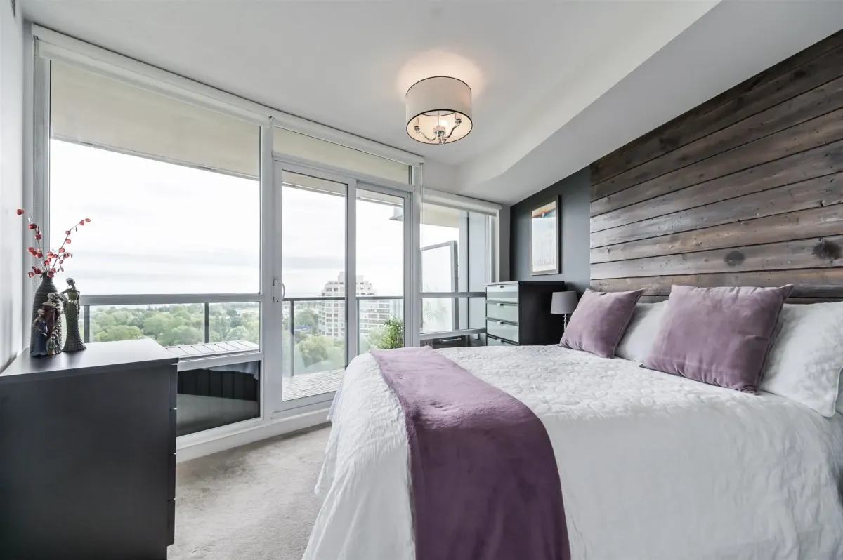 Spacious primary bedroom with large windows and neutral decor in unit 908.