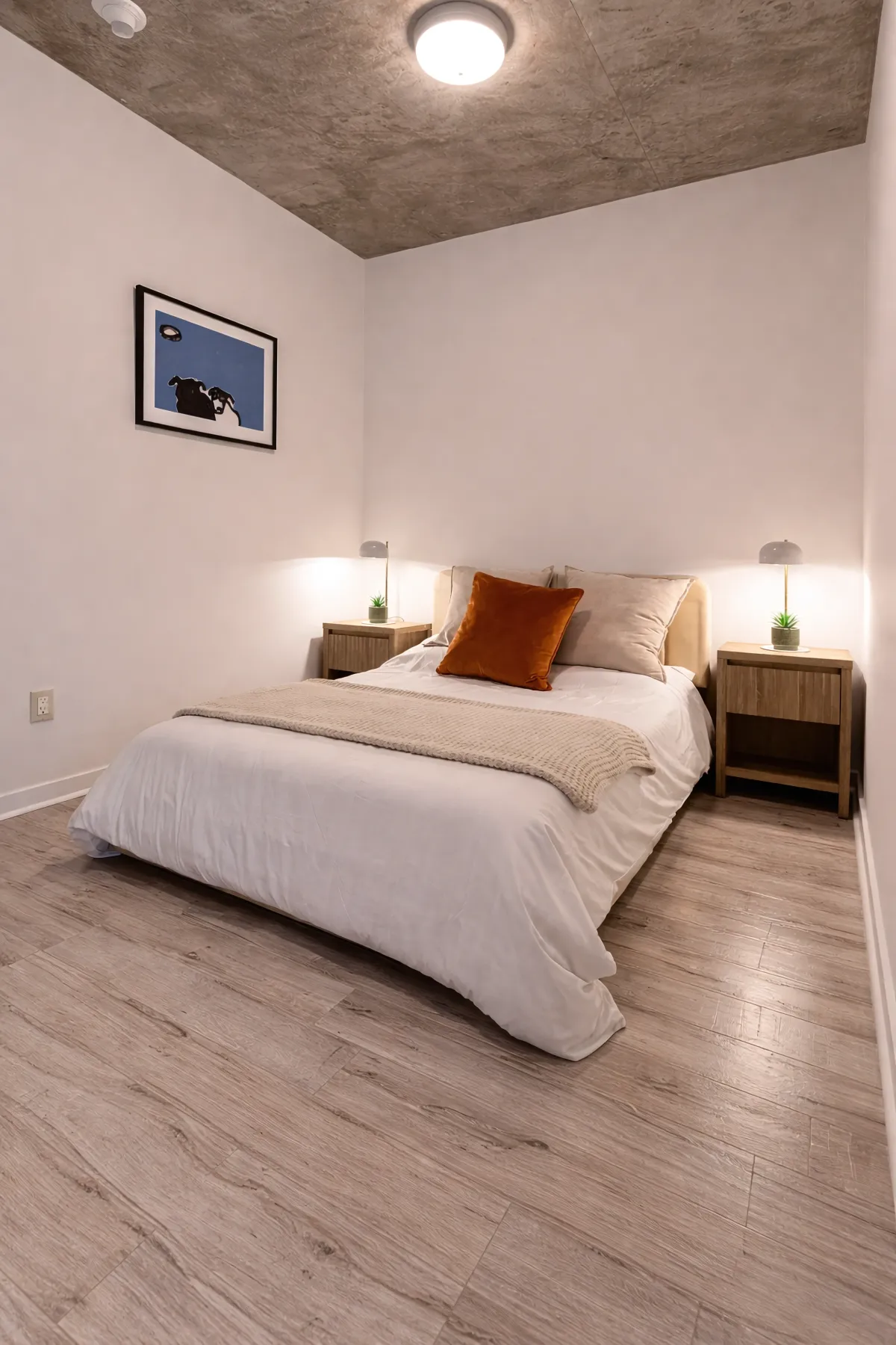 Den used as second bedroom with door, exposed concrete ceiling and hardwood floor