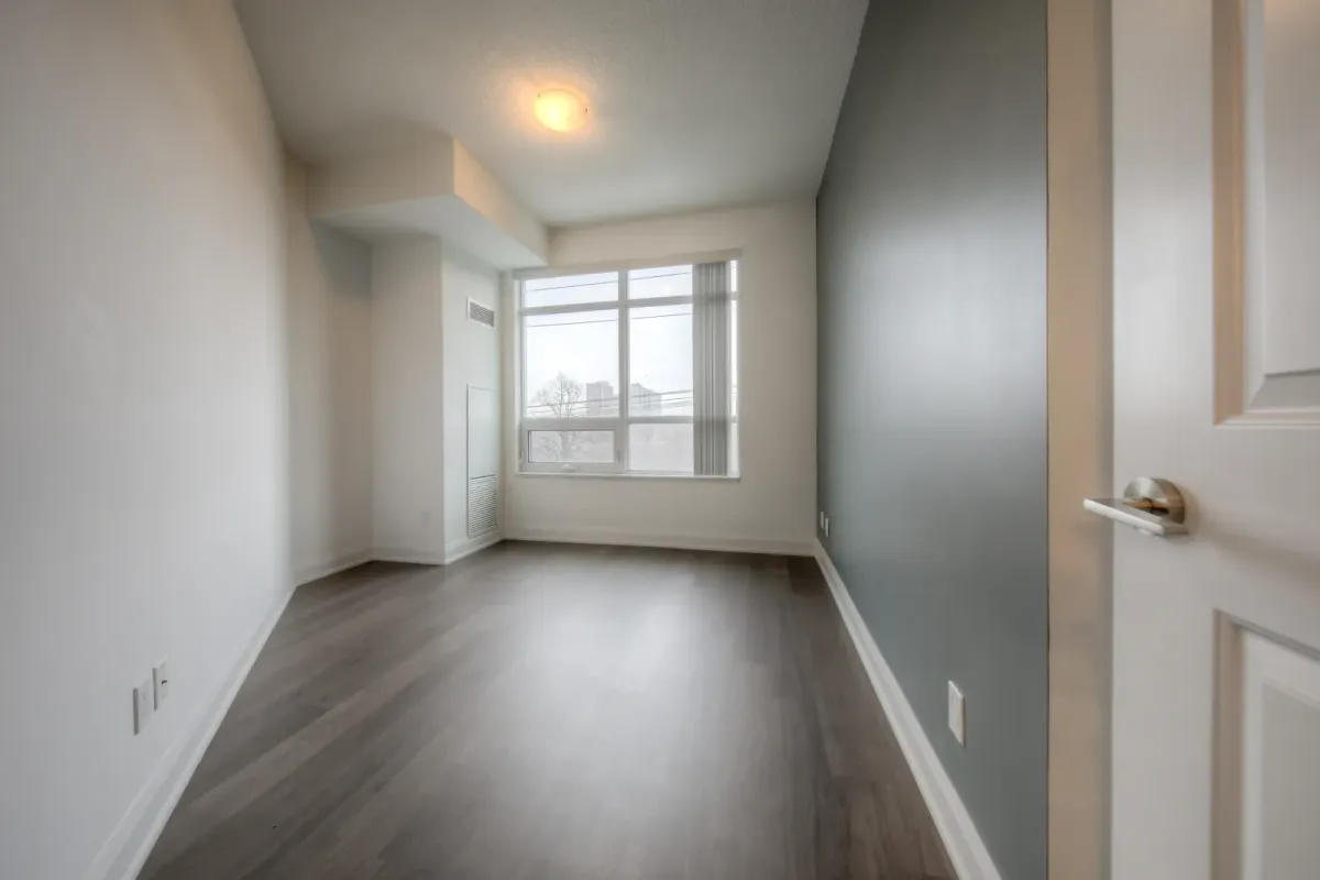 Bedroom with large window and hardwood floor