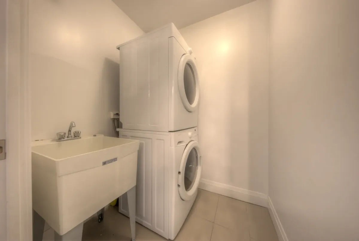 Large laundry room with front loading washer, dryer and sink