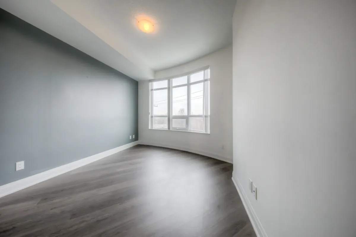 Bedroom with large window and hardwood floor