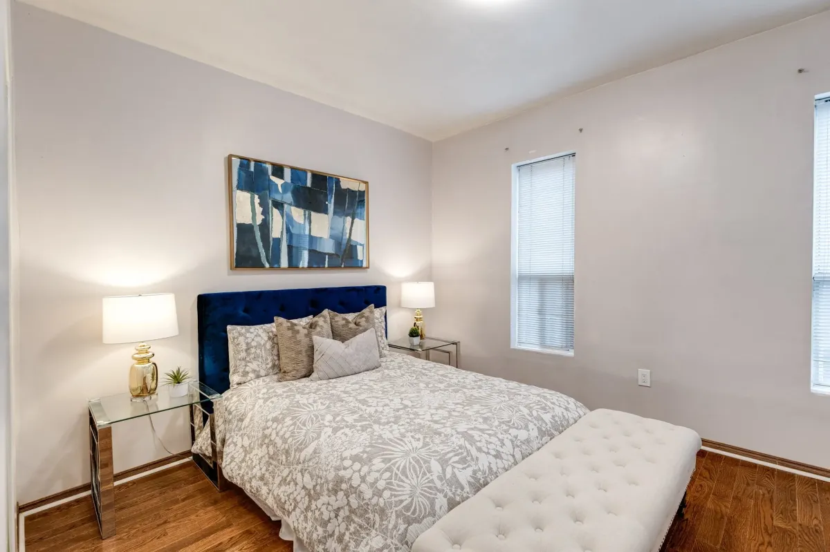 Primary bedroom with 2 windows and vintage original hardwood floor