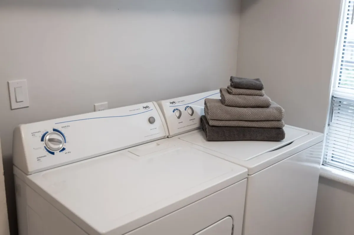 White washer and dryer with neatly folded towels