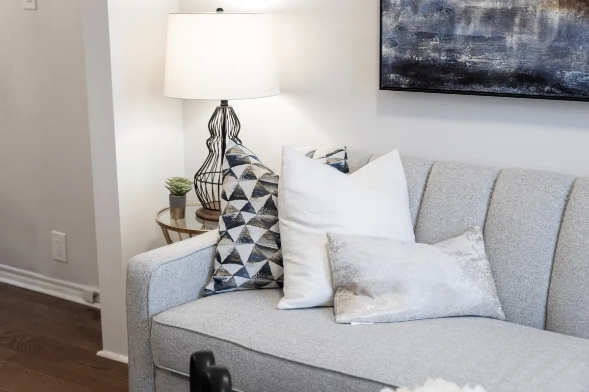 Modern couch with pillows and side table with lamp at 56 Hickson St