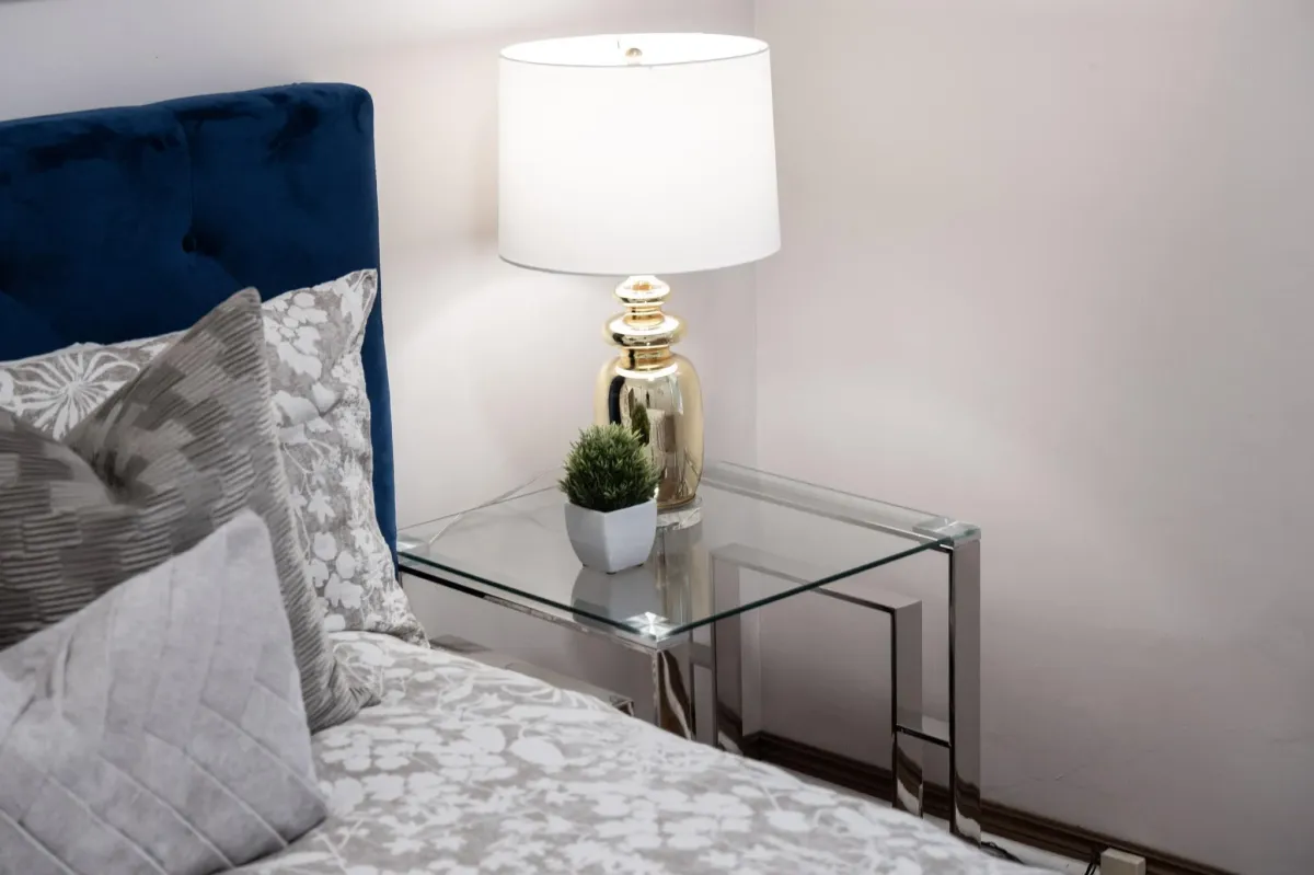 Beautiful glass side table and decor in primary bedroom