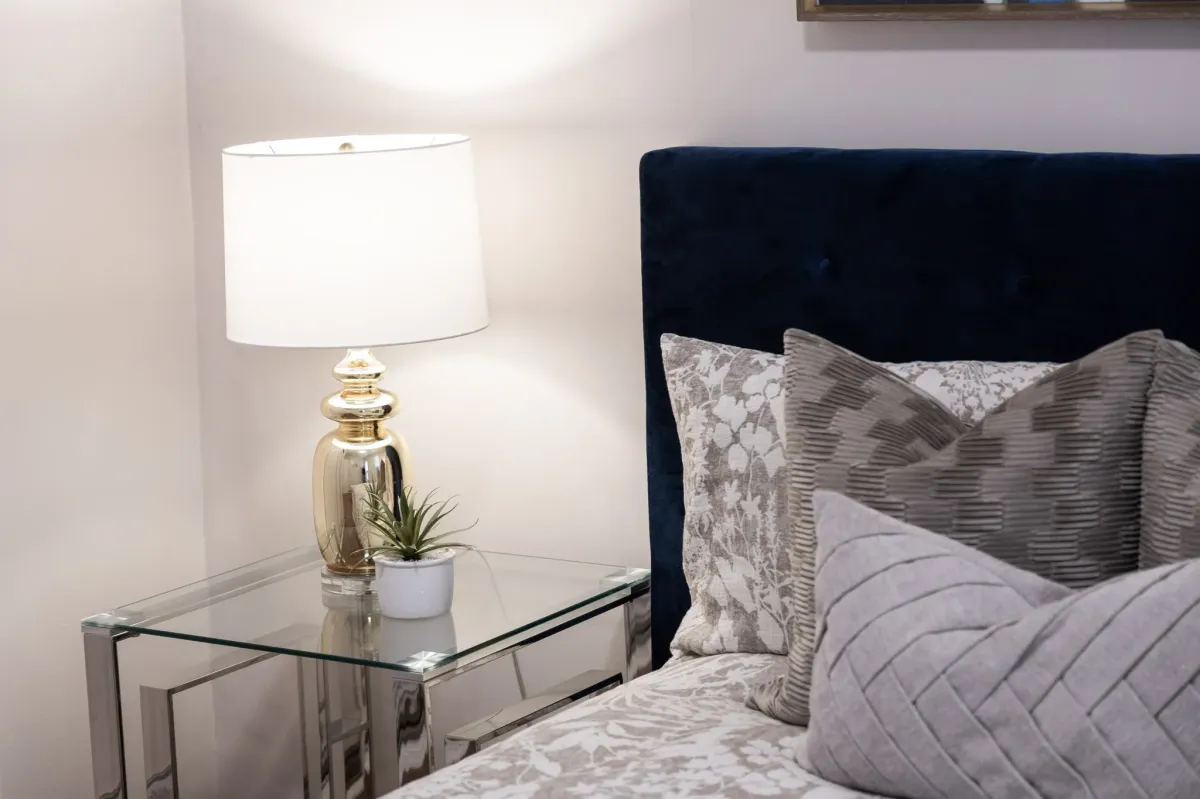 Side table and decor with bed and decorative pillows at 56 Hickson St.