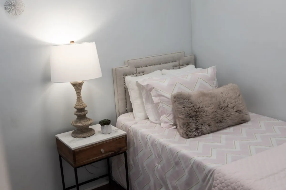 Bed with side table and lamp at 56 Hickson St