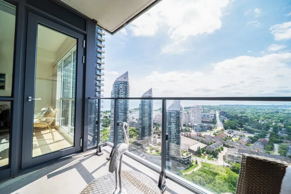 View looking down the length of the balcony at 10 Park Lawn Rd, Unit 3402 with glass railings and city backdrop.