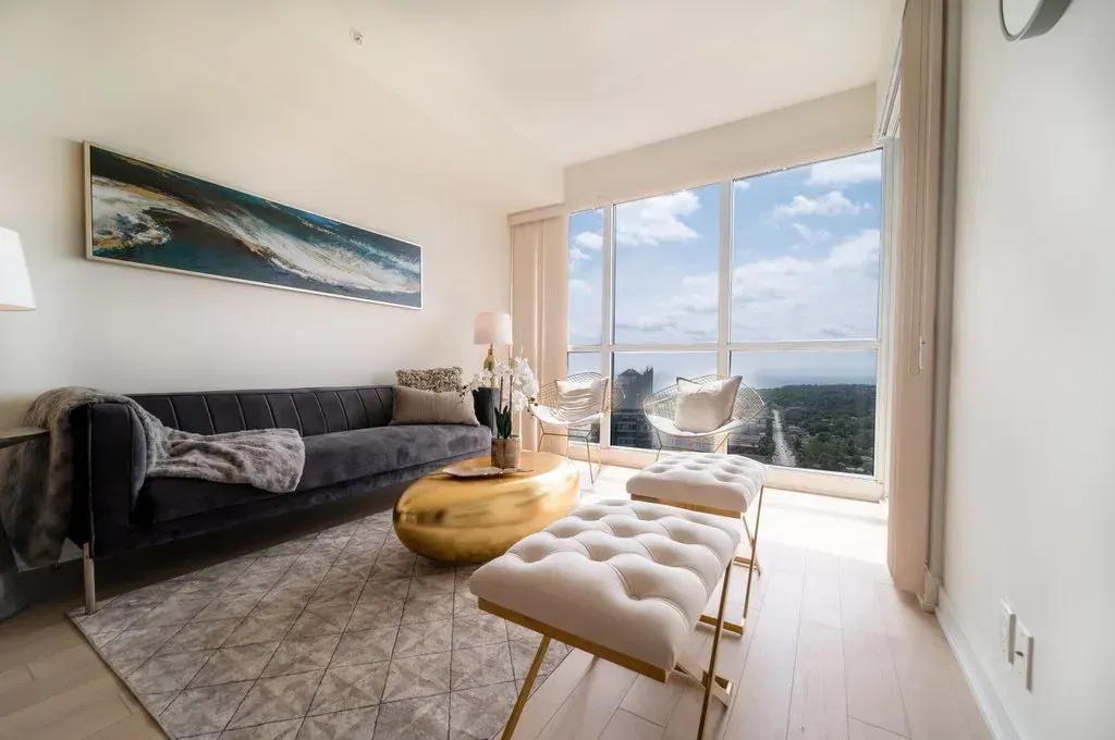 Stylish dark sofa paired with a gold coffee table in the bright living room of 10 Park Lawn Rd, Unit 3402.