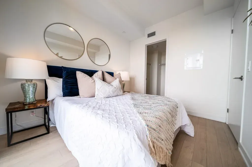 Tranquil bedroom at 10 Park Lawn Rd, Unit 3402 with a navy blue headboard and circular mirrors.