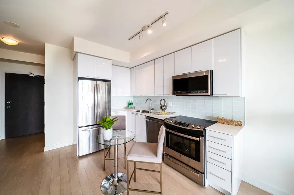 Full view of the 10 Park Lawn Rd, Unit 3402 kitchen featuring white cabinetry and stainless steel appliances.