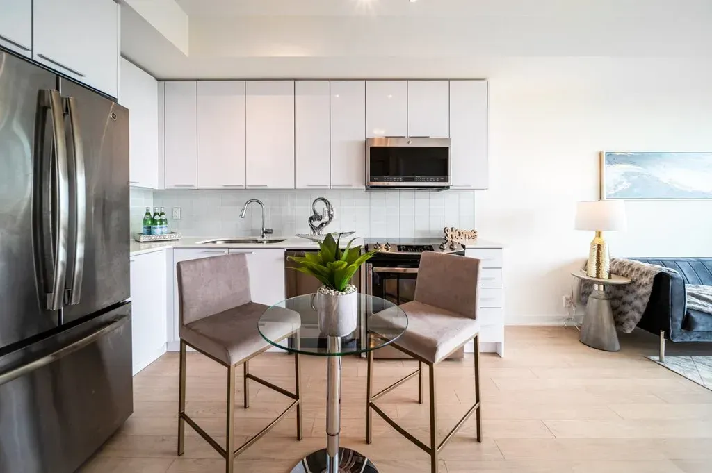 Stainless steel fridge and stove with a glass-top dining table at 10 Park Lawn Rd, Unit 3402.