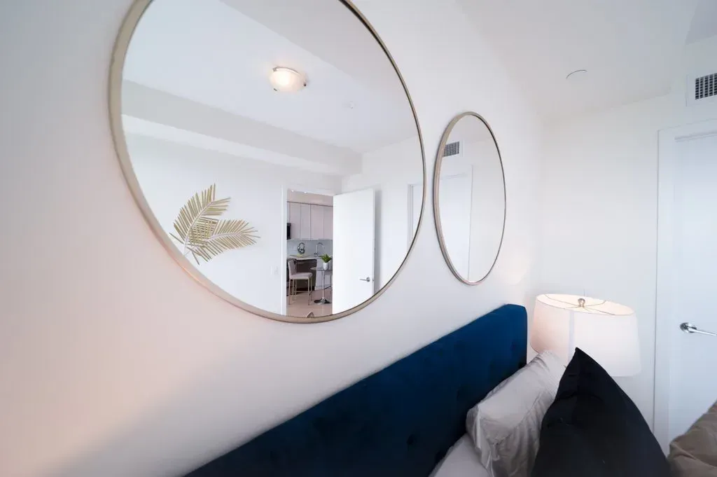 Elegant navy velvet headboard and gold-framed mirrors in the 10 Park Lawn Rd, Unit 3402 primary bedroom.