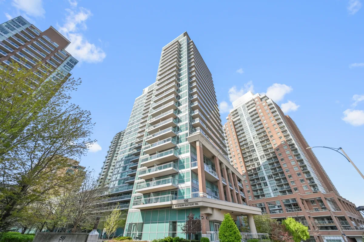 Low-angle view of the prestigious "Vibe" tower at 100 Western Battery Rd, Unit 1911 against a clear blue sky.