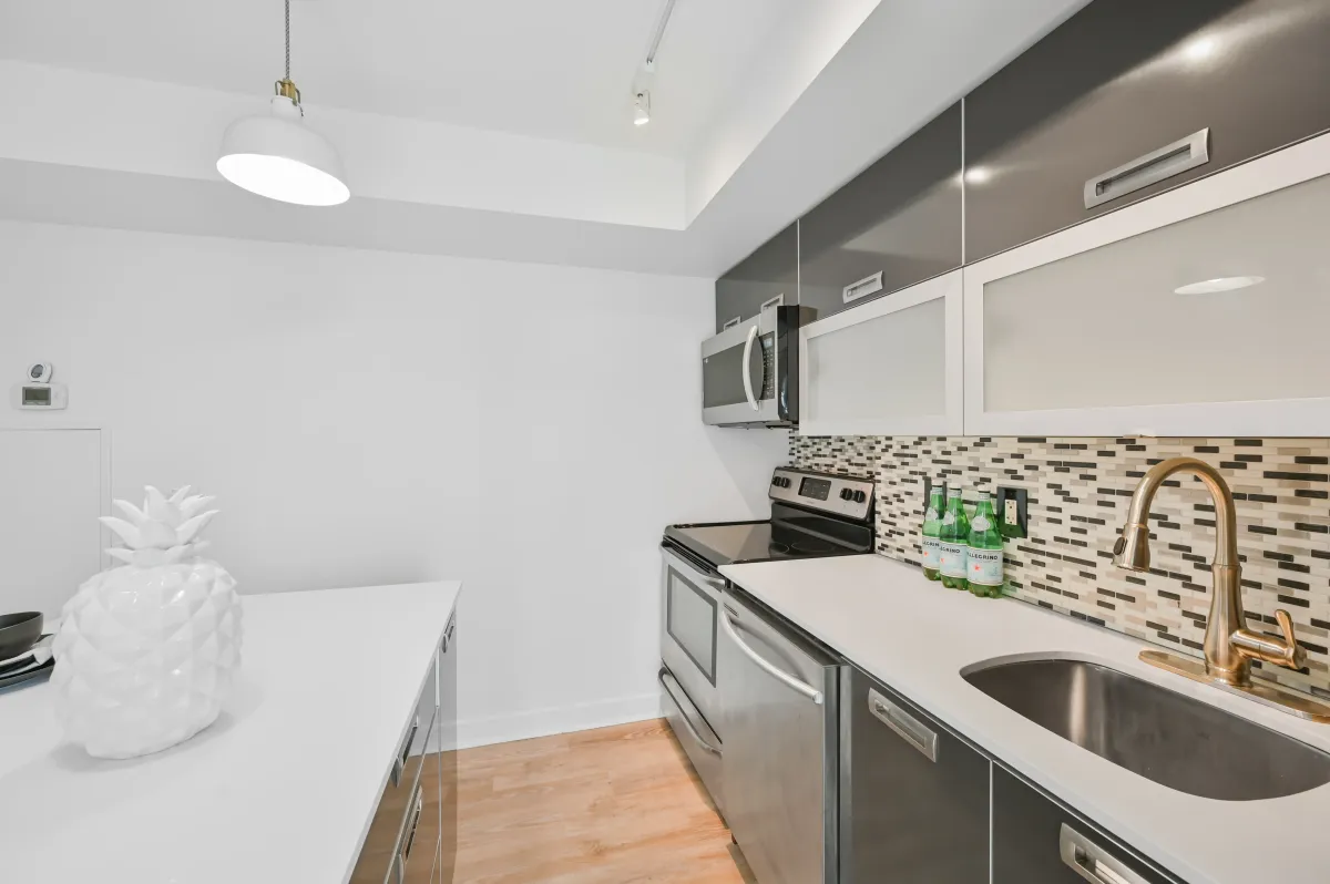 Close-up of the stainless steel appliances and modern backsplash at 100 Western Battery Rd, Unit 1911.