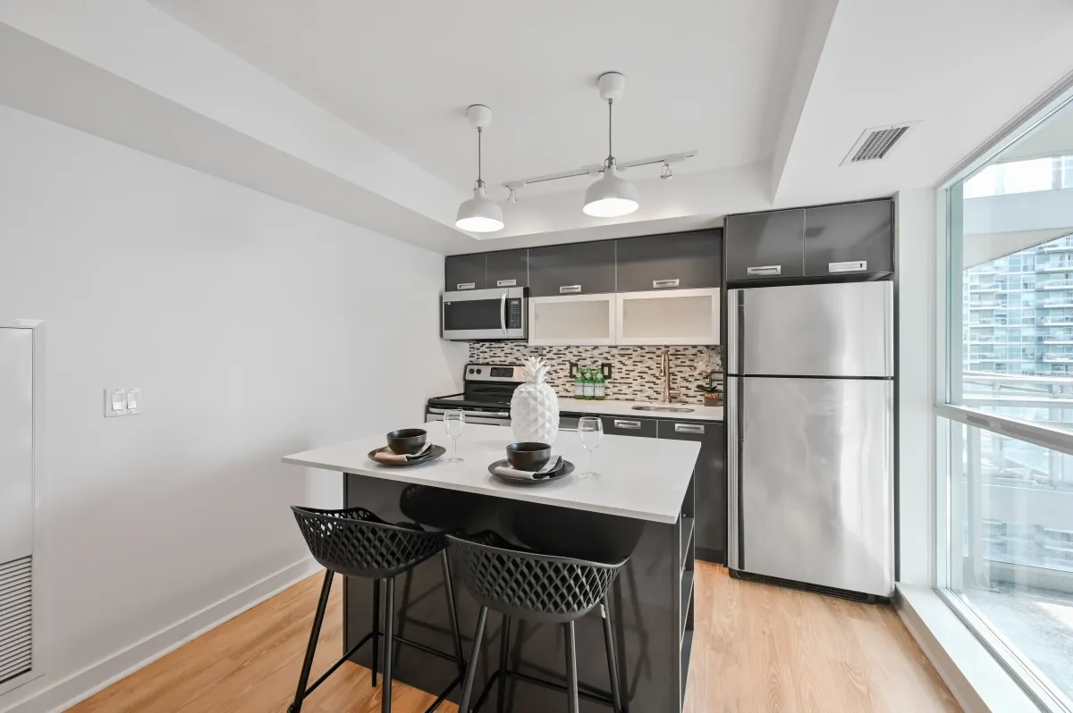 Functional breakfast bar and island with Caesarstone countertops at 100 Western Battery Rd, Unit 1911.