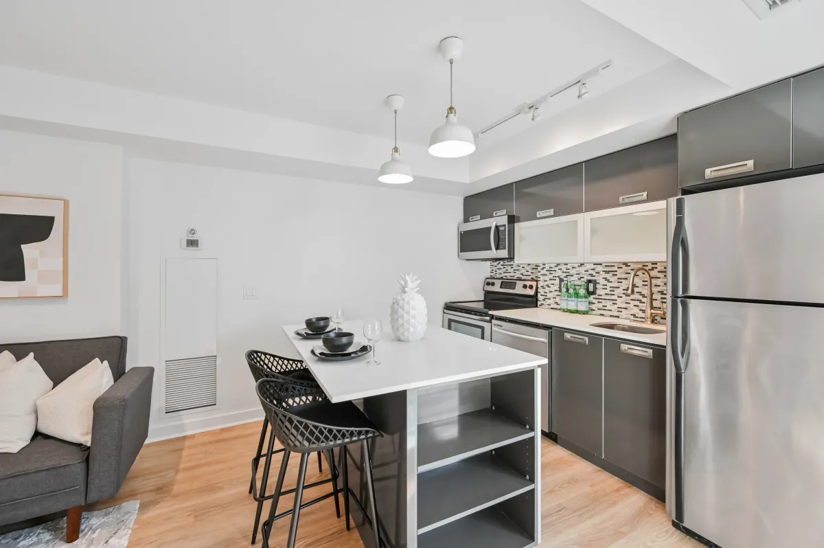 View of the kitchen island and open-concept dining space at 100 Western Battery Rd, Unit 1911.