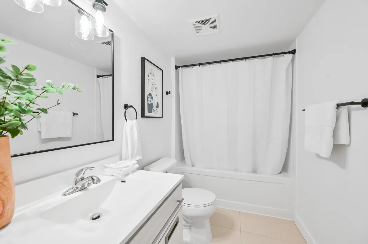 Pristine white bathroom at 100 Western Battery Rd, Unit 1911 with a soaking tub and large vanity mirror.