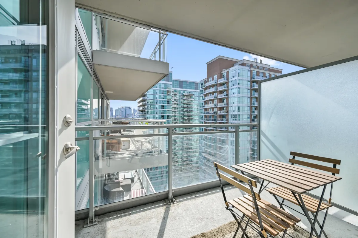Spacious outdoor balcony at 100 Western Battery Rd, Unit 1911 with a bistro set for sunset views.