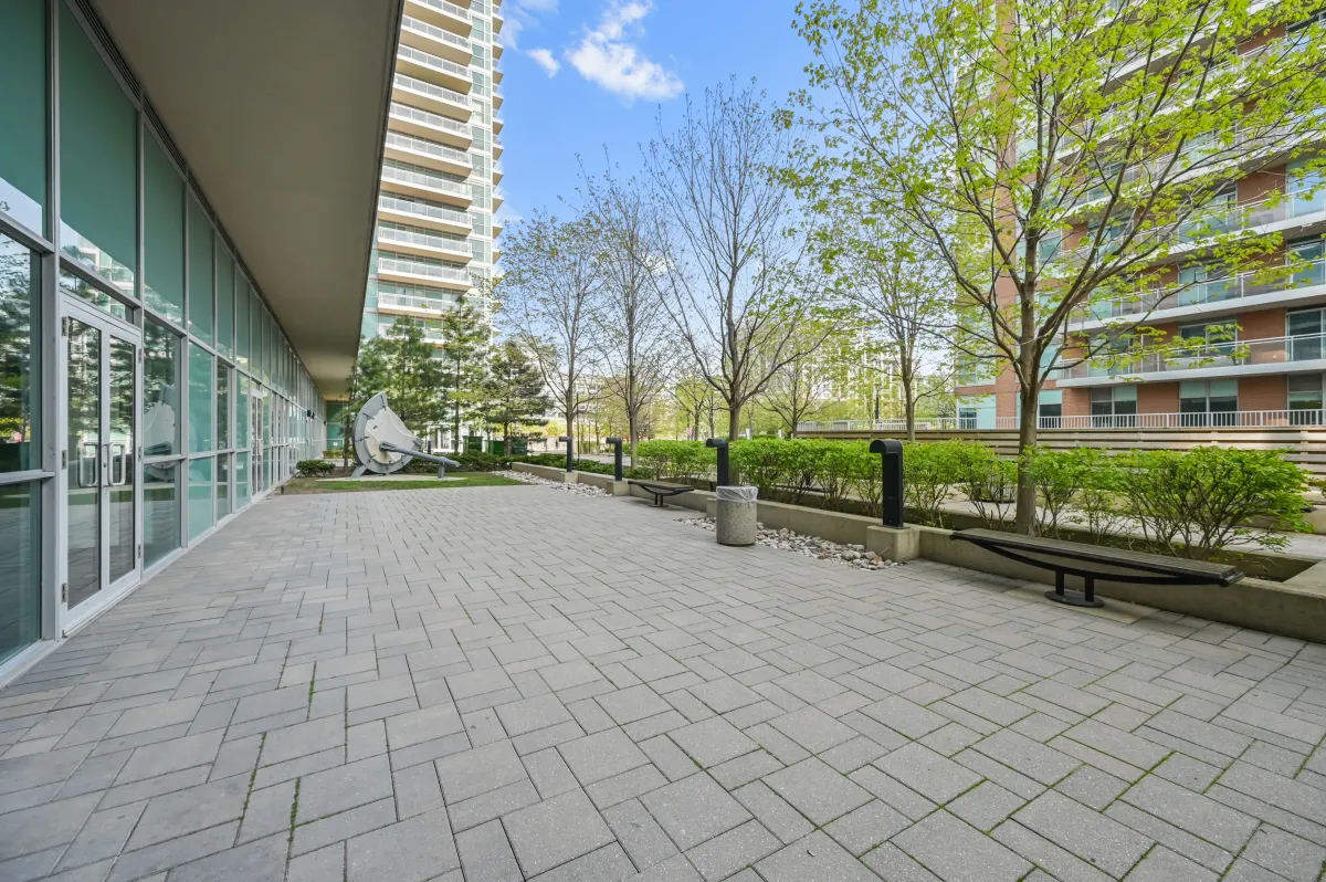 Paved resident terrace and green spaces surrounding 100 Western Battery Rd, Unit 1911.