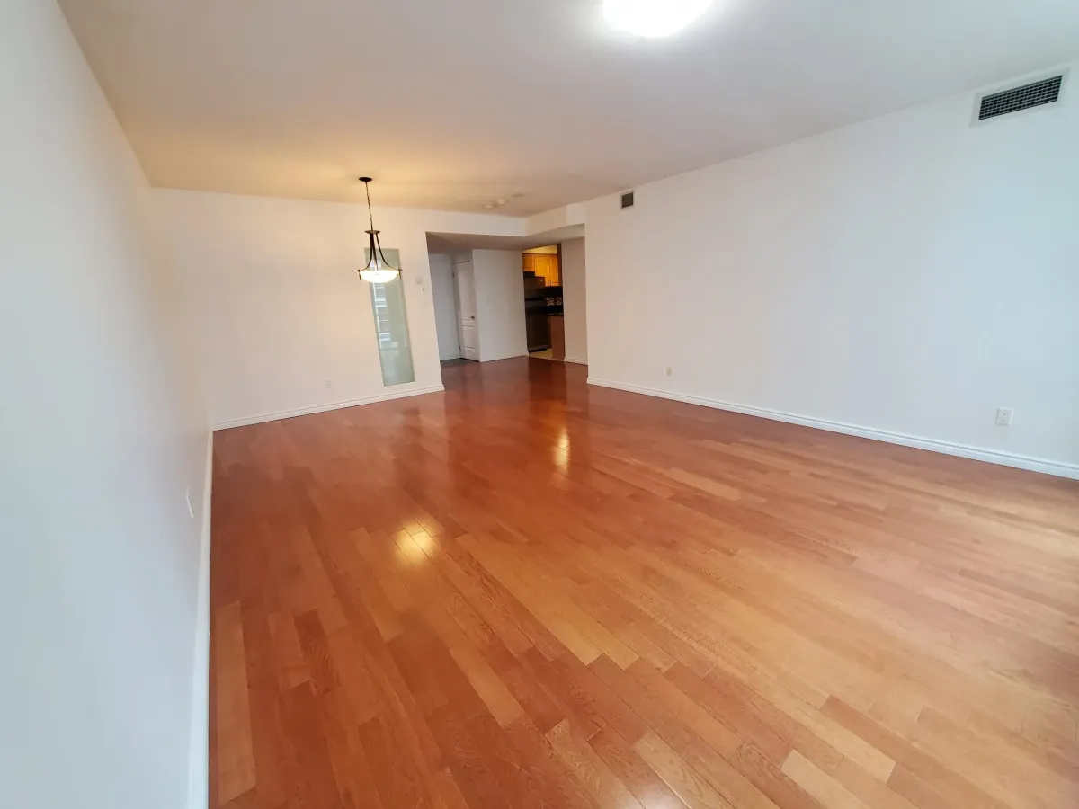 Wide shot of the polished hardwood floors and expansive living area at 263 Wellington St W, Unit 701.