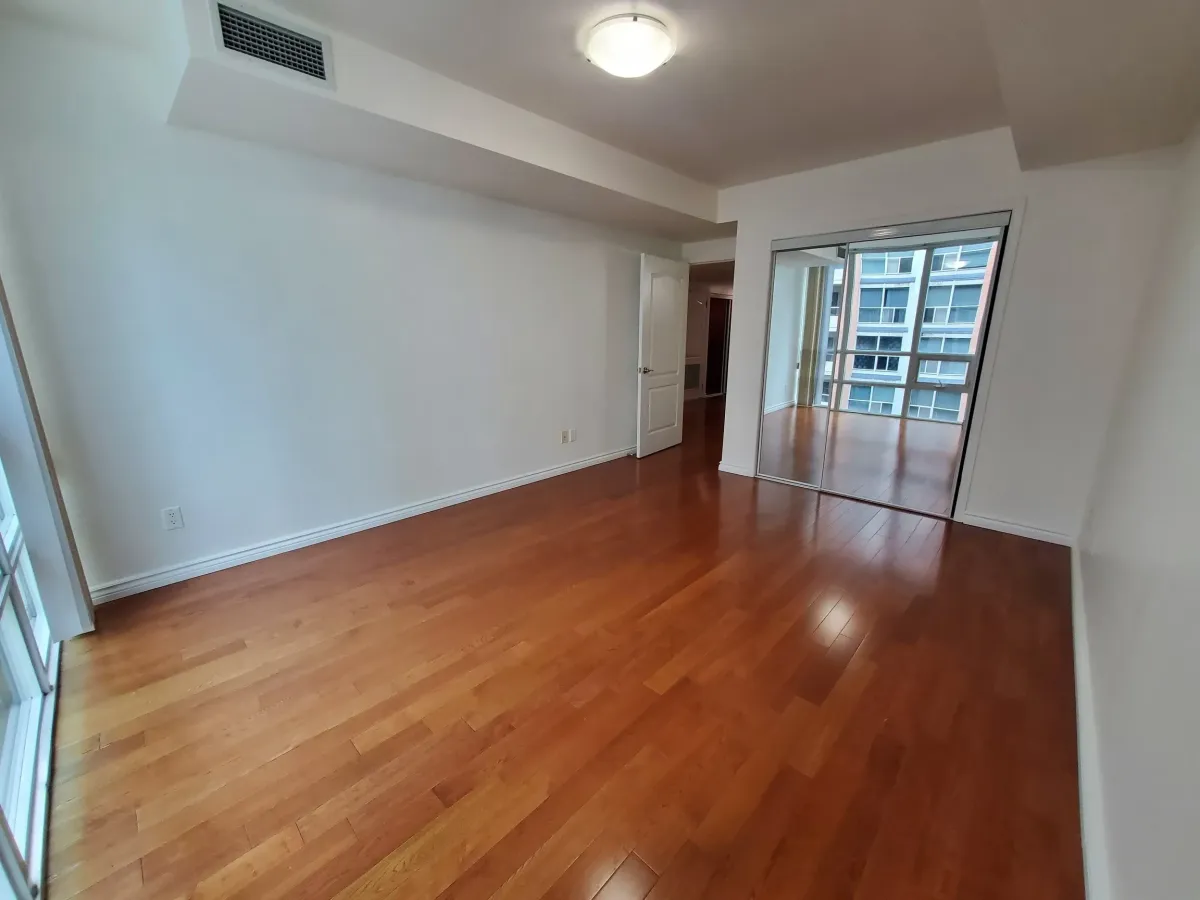View of the oversized living room at 263 Wellington St W, Unit 701 looking toward the private balcony windows.